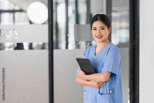 Smiling Female Doctor Holding Tablet in Hospital Lobby. Free Download Smiling Female Doctor Holding Tablet in Hospital Lobby. - GFXLoad