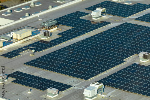 Photovoltaic solar panels mounted on industrial building roof for producing green ecological electricity. Production of sustainable energy concept