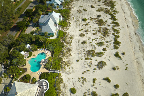 Wealthy neighborhood in small town Boca Grande, Florida with expensive waterfront houses between green palm trees. Development of US premium housing