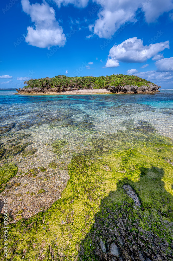 Crystal clear waters of Bise Beach, Motobu District, Okinawa main island. White sand beach with coral outcrops and small islands offshore