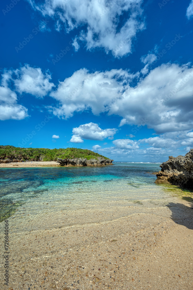 Crystal clear waters of Bise Beach, Motobu District, Okinawa main island. White sand beach with coral outcrops and small islands offshore