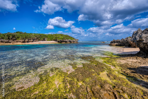 Crystal clear waters of Bise Beach, Motobu District, Okinawa main island. White sand beach with coral outcrops and small islands offshore photo