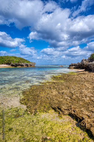 Crystal clear waters of Bise Beach, Motobu District, Okinawa main island. White sand beach with coral outcrops and small islands offshore