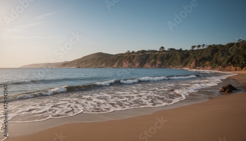 Serene Beach at Sunset with Gentle Waves and Scenic Cliffs