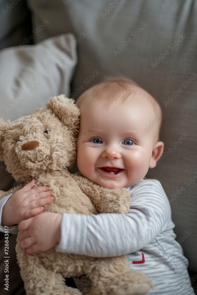a very cute little blue eyed baby smiling, sitting up holding a stuffed bear. a very cute little blue eyed baby smiling, sitting up holding a stuffed bear.