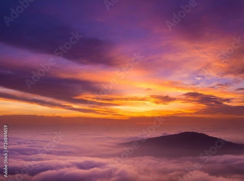 View from a mountain through the clouds. View from on airplane, at sunrise. Beautiful travel wallpaper. Orange dawn. Sense of freedom.