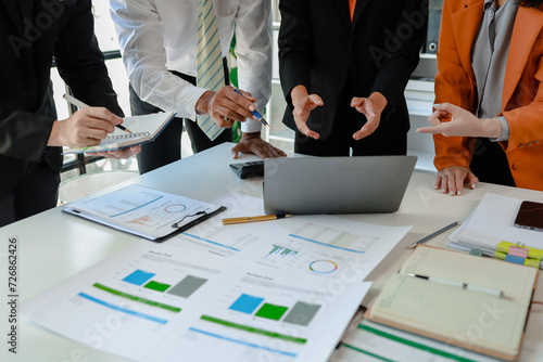 Mixed group of business people sitting around a table and working, Business team working on a project in the office around a table or reviewing and discussing a business project.