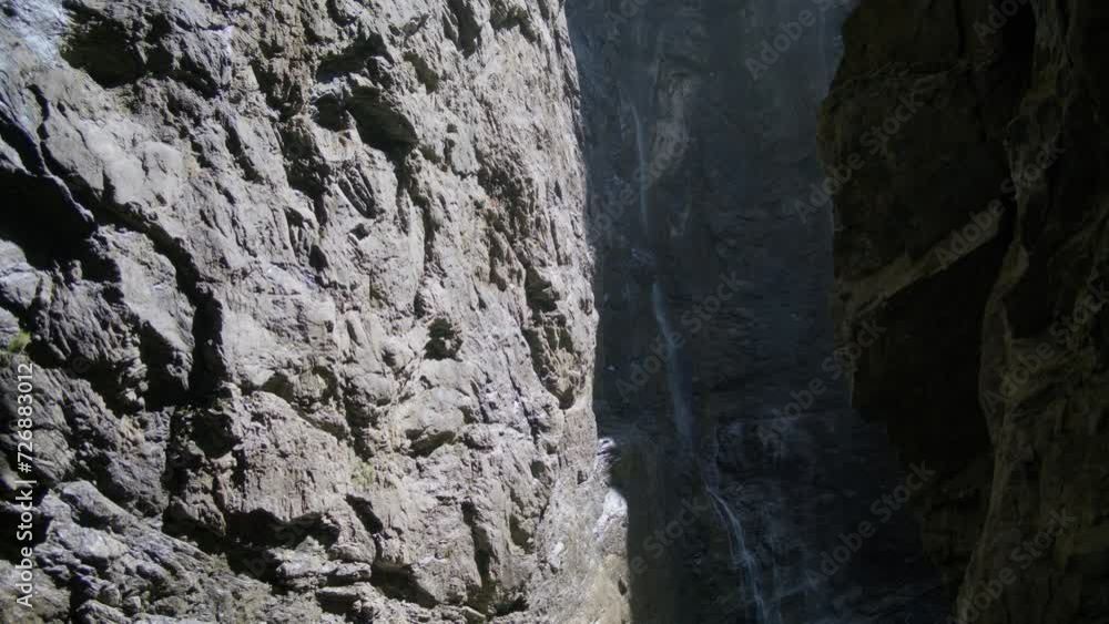 Sunlight Hitting Rocks With Flowing Waterfall In Distance | Grindelwald Switzerland Cave in Glacier Canyon, Europe, 4k Sunlight Hitting Rocks With Flowing Waterfall In Distance | Grindelwald Switzerland Cave in Glacier Canyon, Europe, 4k