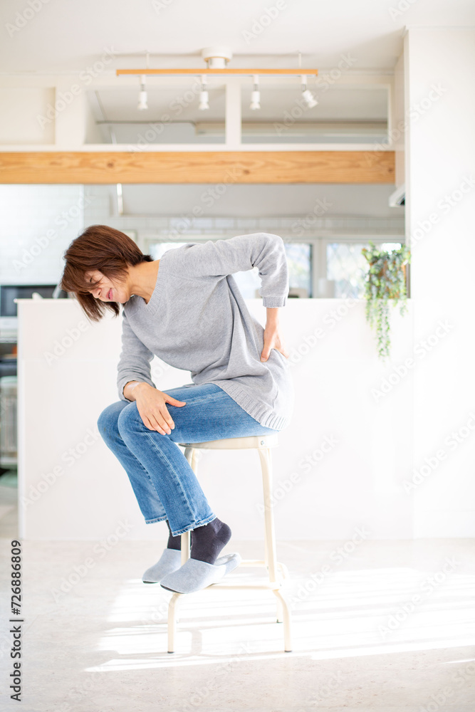 腰痛に悩む日本人のミドル女性 腰痛に悩む日本人のミドル女性