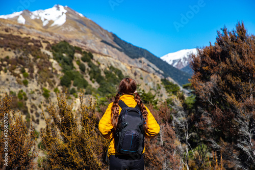 hiker girl walking on a bealey spur track in arthur's pass national park, canterbury, new zealand; hiking on a scenic track in new zealand alps