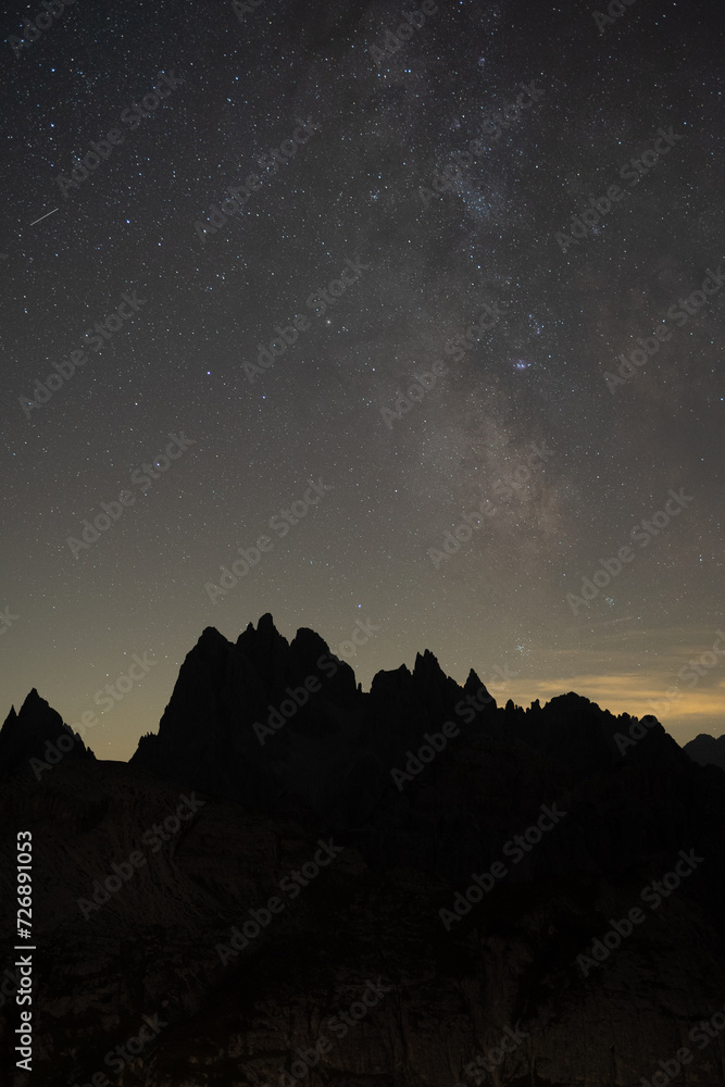 the moon and stars fill the sky over the mountains at night the moon and stars fill the sky over the mountains at night