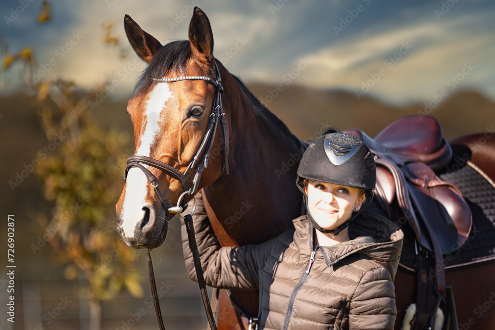 Obraz premium Horse stands with his rider on a meadow in the sun ready to ride out.
