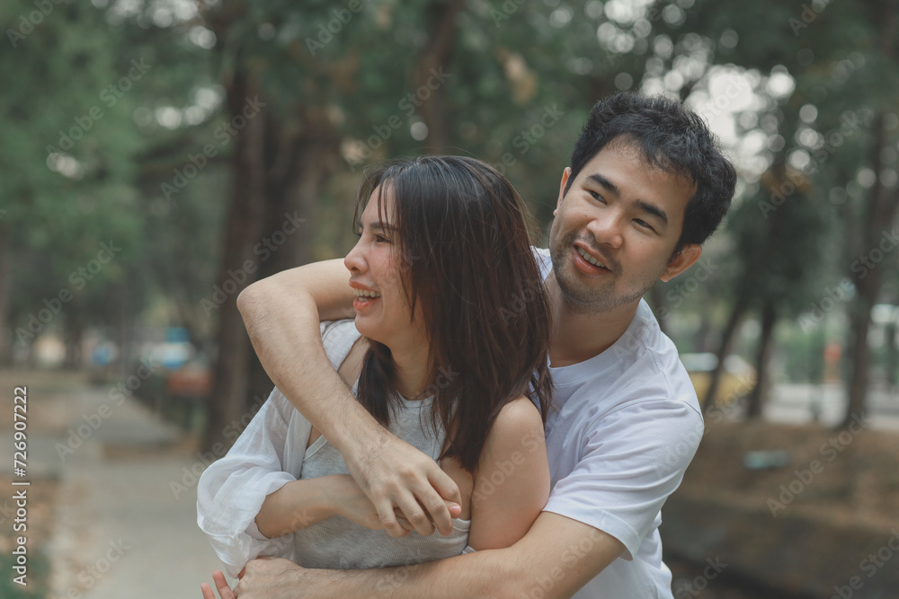 Happy young Asian couple in a park, Portrait of smiling couple near beautiful nature outdoors, lifestyle, Cheerful couple hugging each other, Young couple enjoying the sunny day at park Happy young Asian couple in a park, Portrait of smiling couple near beautiful nature outdoors, lifestyle, Cheerful couple hugging each other, Young couple enjoying the sunny day at park