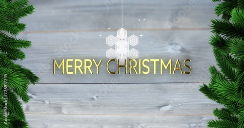 Image of merry christmas text over snowflake and fir tree branches on wooden background