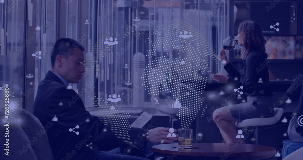 Fototapeta premium Digital icons and spinning globe against asian businesspeople using digital tablet at a bar