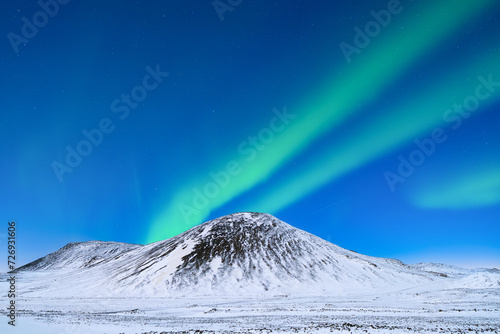 Aurora Borealis. Northern Lights over the mountains. A winter night landscape with bright lights in the sky. Landscape in the north in winter time. A popular place to travel.