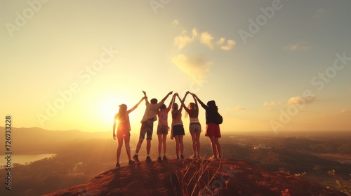 Group of friends supporting and motivating each other to reach the breathtaking mountain peak photo