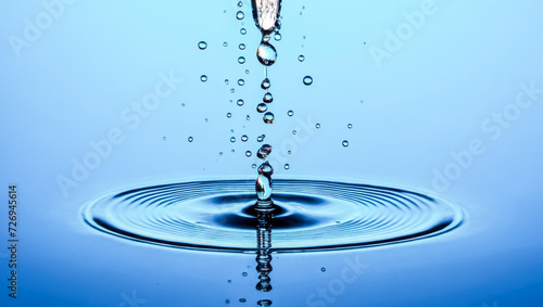 Stream of water droplets falls, creating ripples on impact with serene blue surface. Each drop captured in stunning detail against tranquil backdrop, embodying purity and calmness