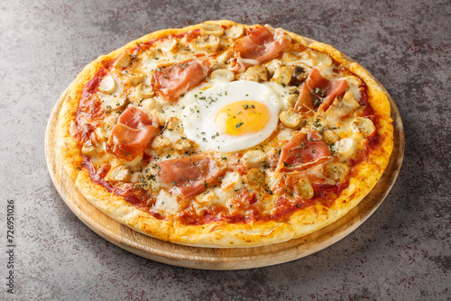 Foto Pizza Bismarck is a style of pizza in Italian cuisine prepared with tomato sauce, mozzarella, mushrooms, prosciutto, and egg closeup on the wooden board on the table
