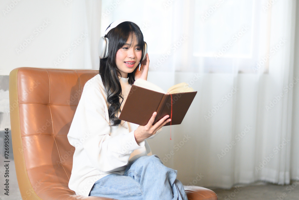 Obraz premium woman in shirt Read a book with headphones