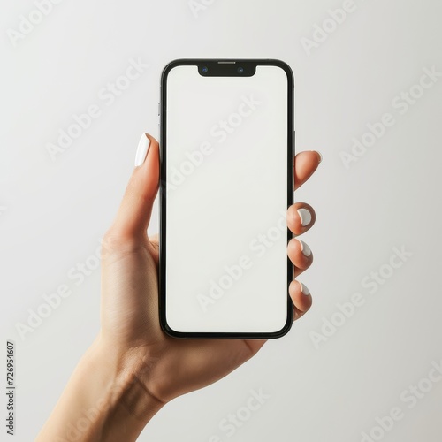 female hand holding a smartphone with a blank white screen - mockup template on white background