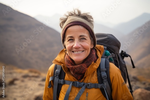 Portrait of a smiling senior woman with backpack in the mountains.