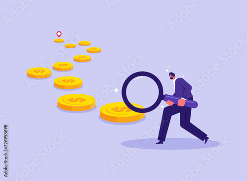 Looking for business opportunities and ways to make money concept, businessman holding a magnifying glass looking for the trail of money gold coins