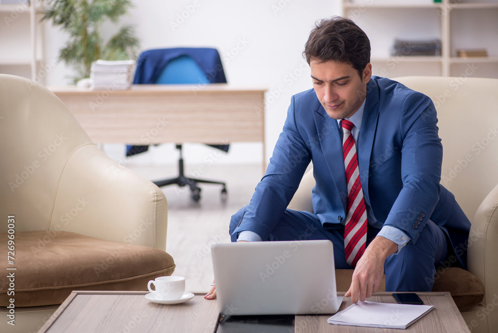 Young male employee sitting in the office Young male employee sitting in the office