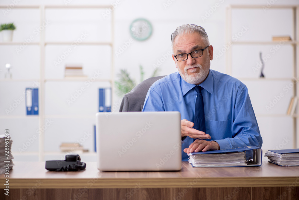 Old male employee working in the office Old male employee working in the office