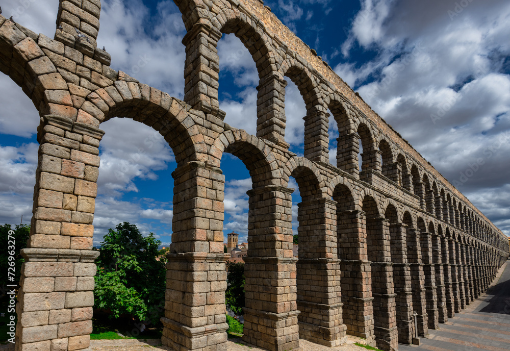 Ancient Roman aqueduct on Plaza del Azoguejo square and old building towns in Segovia, Spain