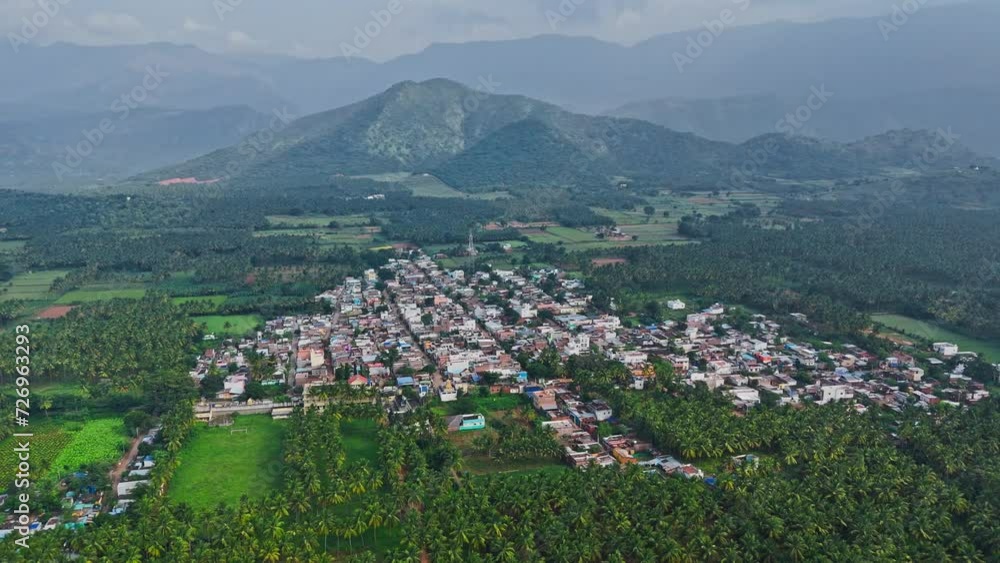 Profile view of a crowded city with trees and hills during a foggy cloudy day in Theni, Tamil Nadu. Aerial Shot. Profile view of a crowded city with trees and hills during a foggy cloudy day in Theni, Tamil Nadu. Aerial Shot.