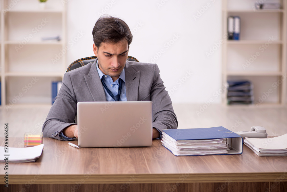 Young male employee working in the office Young male employee working in the office