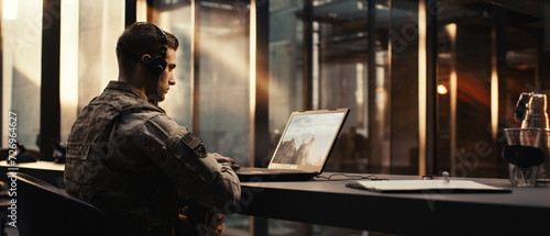 Soldier working with laptop in headquarters