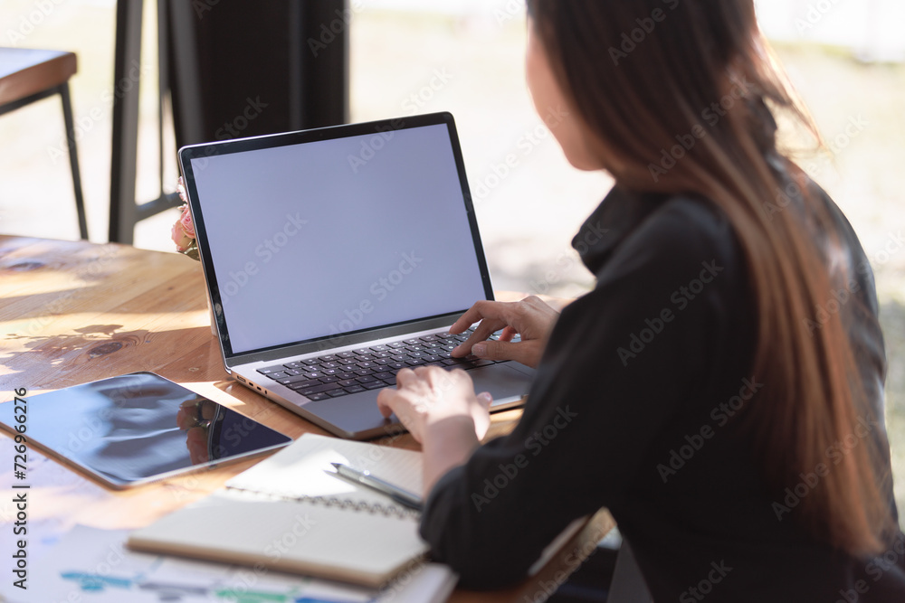 Woman typing on a notebook while working on a new project, Remote work in a modern workspace. Woman typing on a notebook while working on a new project, Remote work in a modern workspace.