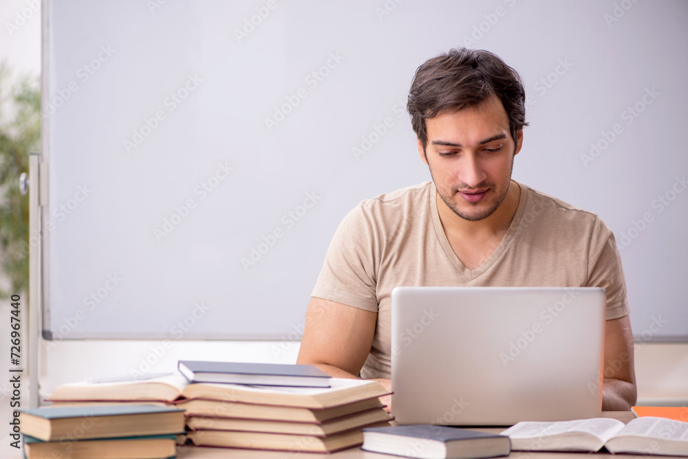 Young male student in tele-education concept Young male student in tele-education concept