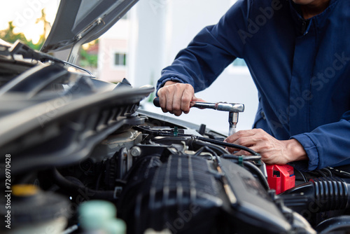 Car service , Professional mechanic working on the engine , repairing a car engine automotive workshop with a wrench, car service and maintenance ,Repair service.