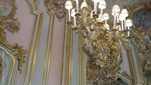 Historical interiour details of an golden angel hoding small lamps and ornamentet wall of Villa Cora in florence tuscany italy