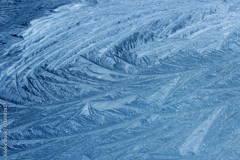 Frost flowers on a frozen flat surface in winter blue ice pattern background texture Frost flowers on a frozen flat surface in winter blue ice pattern background texture
