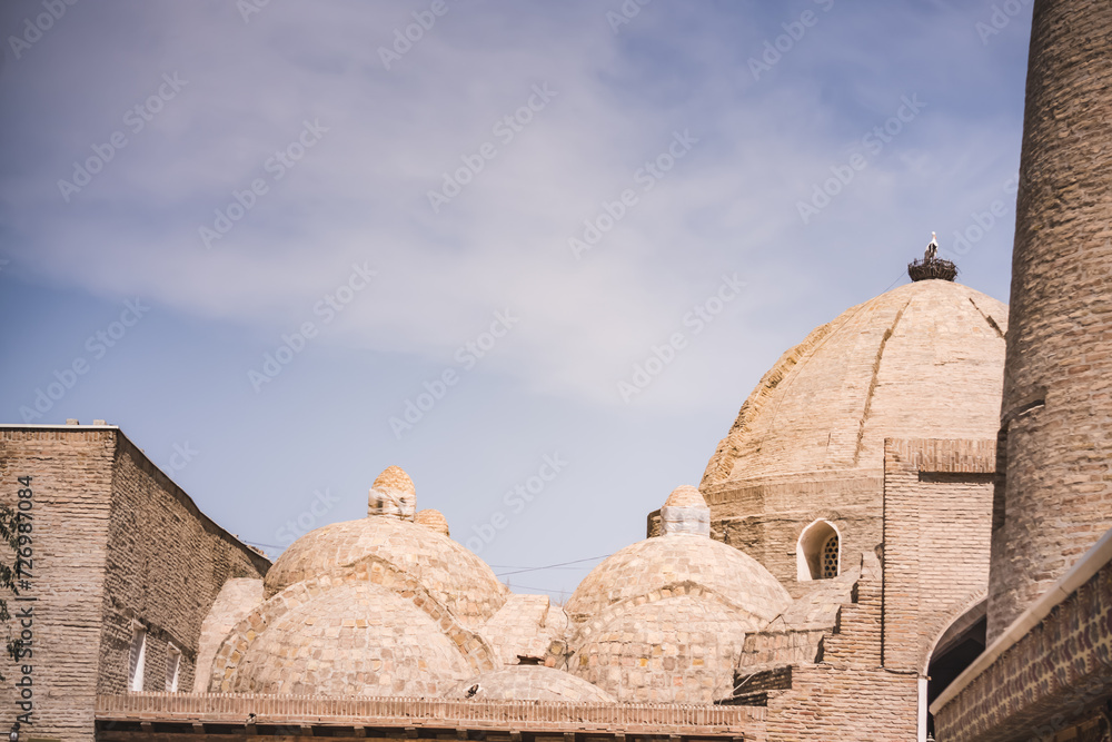 Fototapeta premium Urban architecture of mosques and madrassas in the ancient city of Bukhara in Uzbekistan in oriental style, ancient oriental buildings