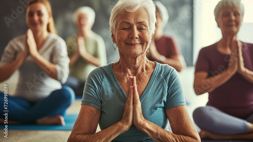 Seniors participating in a yoga class. Diverse group, gentle poses. Smiles and relaxation. Active aging, well-being focus. photo