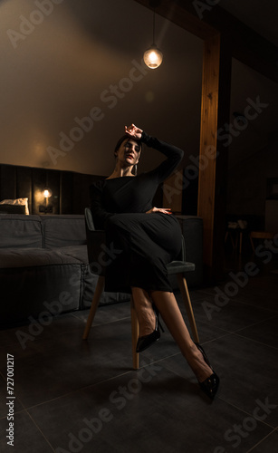 Elegant woman in a black dress posing in an apartment. Fashion shooting concept. Valentine's Day