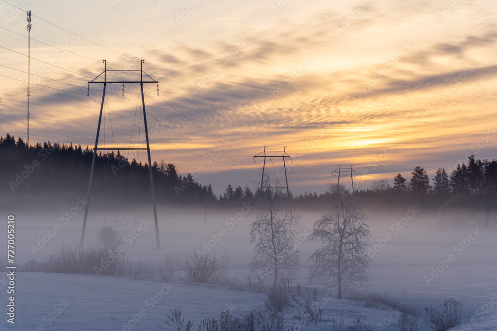 Power towers and electric wires at hazy winter scenery in Finland Power towers and electric wires at hazy winter scenery in Finland