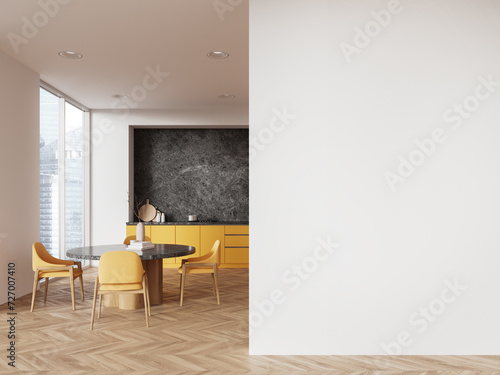 White and yellow kitchen interior with dining table and blank wall