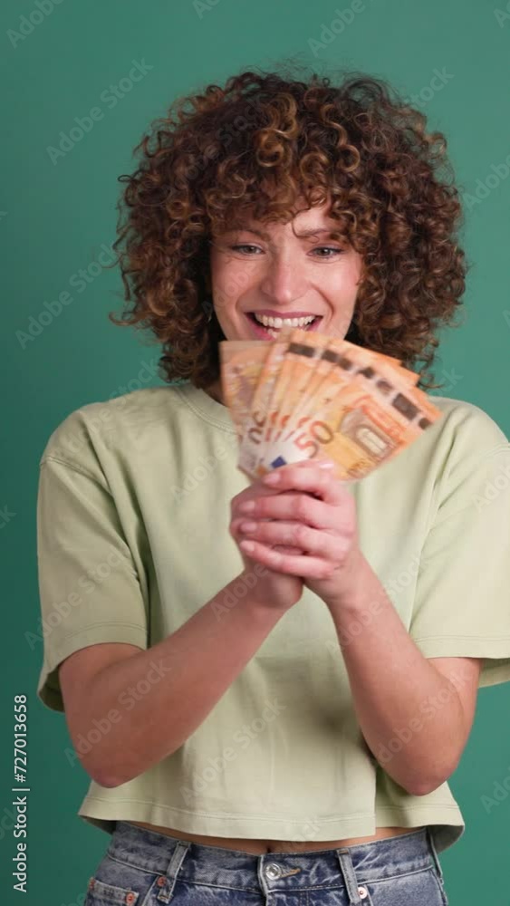 Cheerful woman showing Euro banknotes in green studio. Vertical footage Cheerful woman showing Euro banknotes in green studio. Vertical footage