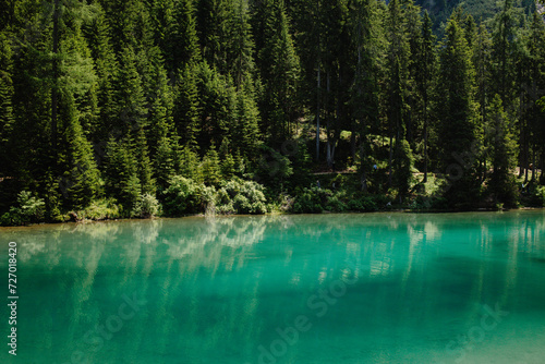 Serene Turquoise Mountain Lake Surrounded by a Dense Pine Forest Valley