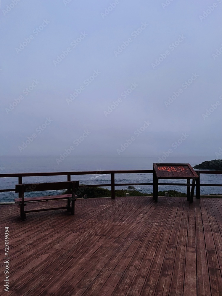 twilight at the ocean coast, dark sky, foggy and misty ocean view, point of view, no people