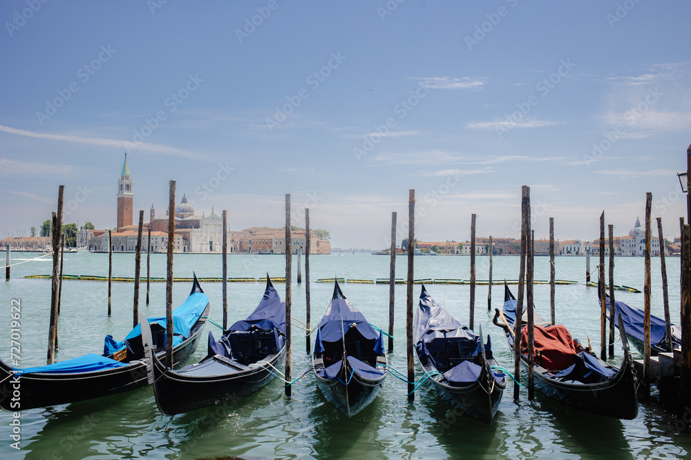Gondolas docked in Venice with a beautiful cityscape in the background