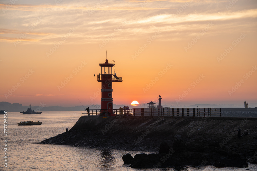 Dawn on the beach with a lighthouse view
