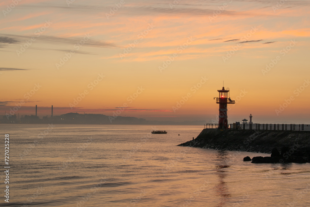 Dawn on the beach with a lighthouse view
