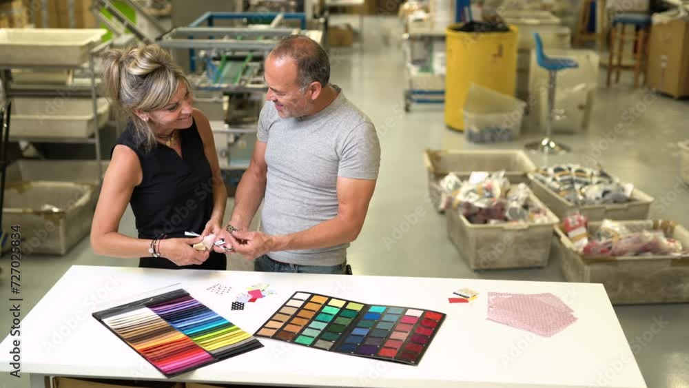 couple of European stylist choosing the right pantone colour inside a textile fabric factory couple of European stylist choosing the right pantone colour inside a textile fabric factory